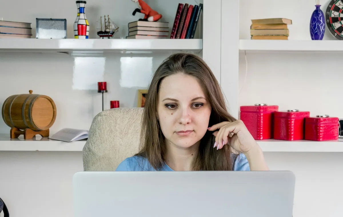 Emprendedora pensativa frente al computador decidiendo qué plataforma de e-commerce elegir